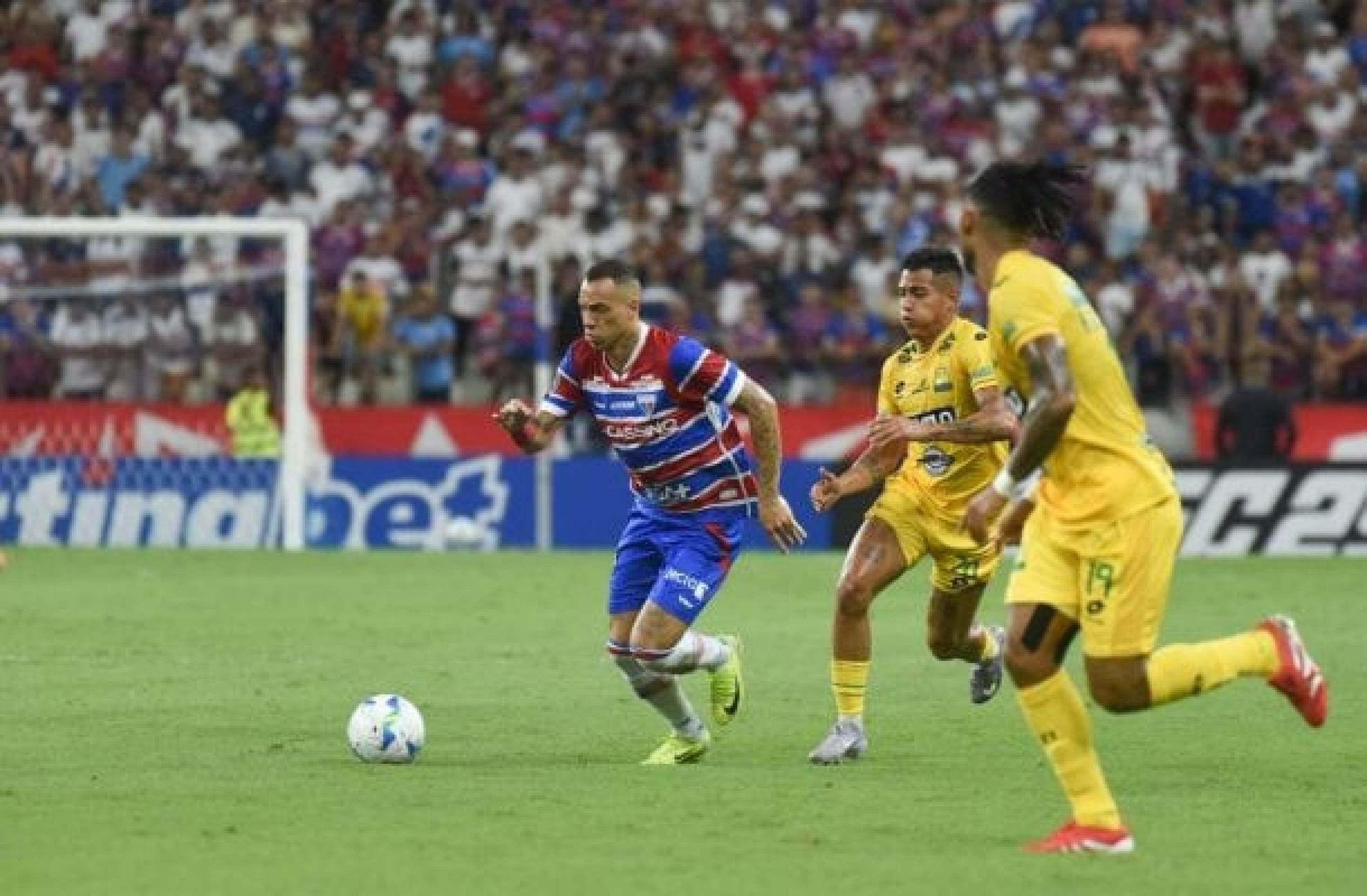 Breno Lopes, do Fortaleza, dispara rumo ao ataque e é marcado de perto por dois rivais do Bucaramanga -  (crédito: Foto: Divulgação/Conmebol)
