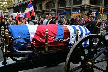  People applaud as the carriage carrying the remains of the late Uruguay's former president (2010-2015) Jose 'Pepe' Mujica moves forward during the funeral cortege in Montevideo, on May 14, 2025. Mujica, an ex-guerrilla fighter and hero of the Latin American left, died on May 13, 2025 at the age of 89. The humble leader -- who once spent a dozen years behind bars for revolutionary activity -- lost his battle against cancer after announcing in January the disease had spread and he would stop treatment. (Photo by Pablo PORCIUNCULA / AFP)
       -  (crédito:  AFP)
