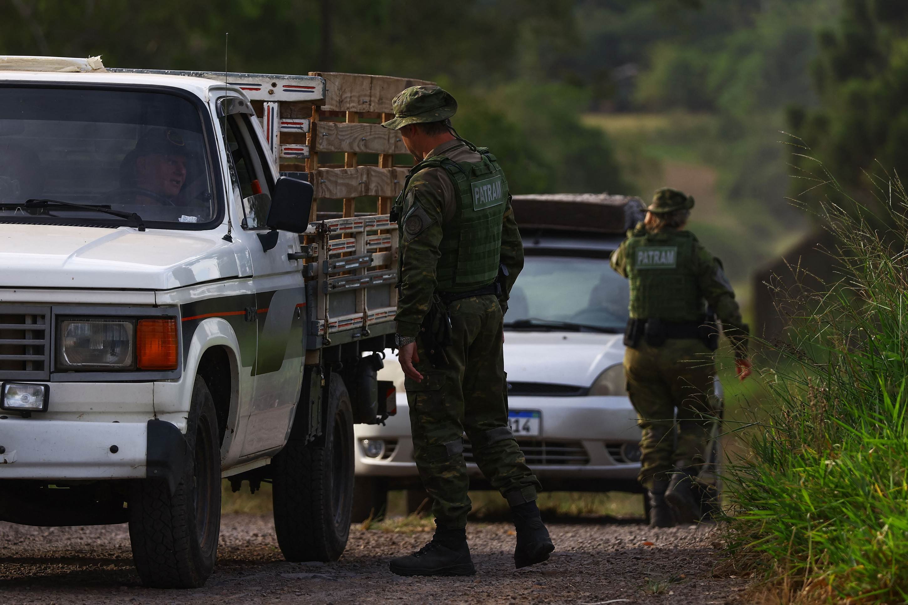 Agentes da Patrulha Ambiental da Brigada Militar (PATRAM) verificam veículos perto de uma granja comercial de aves, local do primeiro surto de gripe aviária do país, em Montenegro, estado do Rio Grande do Sul, Brasil, em 17 de maio de 2025      