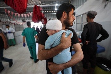 Homem segura bebê ferido na cabeça: ONU teme 14 mil óbitos      -  (crédito:  AFP)