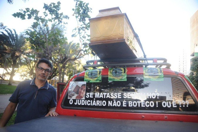 Carlos Roberto Botelho busca justica com as proprias maos depois que o caso de seu filho foi arquivado pela justica. Cidadao de Montes Claros carlos Roberto perdeu seu filho em 2020 quando Lucas morreu em circustancias nao esclarecidos pela Policia depois de uma briga com sua mulher suspeita de traicao com um vizinho de predio. Carlos Roberto busca a reabertura do inquerito na Justica