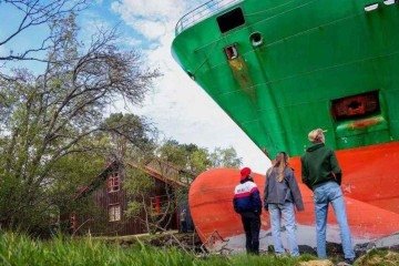 Homem acorda e se depara com enorme navio cargueiro no seu jardim -  (crédito: EPA)