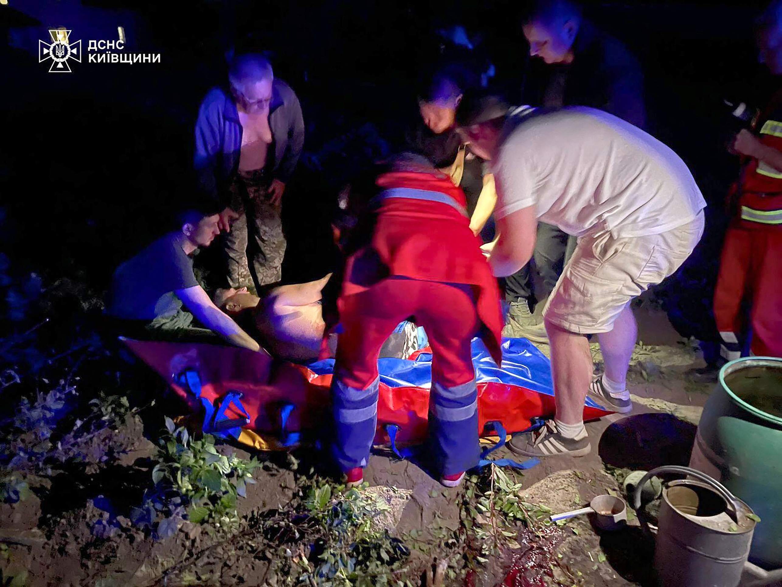 Bombardeio russo feriu civis que estavam em áreas residenciais This handout photograph taken and released by the Ukrainian State Emergency Service press service on May 24, 2025, shows resquers and locals helping an injured person following Russian strike in Kyiv, amid Russian invasion in Ukraine. At least eight people were wounded in a drone and missile attack on Kyiv on May 24, 2025, city authorities said, just as Russia and Ukraine were in the middle of a major prisoner swap. The head of Kyiv's civil and military administration, Tymur Tkachenko, reported fires and fallen debris in several parts of the Ukrainian capital, after AFP journalists heard explosions overnight. (Photo by Handout / Ukrainian State Emergency Service Press Service / AFP) / RESTRICTED TO EDITORIAL USE - MANDATORY CREDIT "AFP PHOTO / Ukrainian State Emergency Service press service" - HANDOUT - NO MARKETING NO ADVERTISING CAMPAIGNS - DISTRIBUTED AS A SERVICE TO CLIENTS