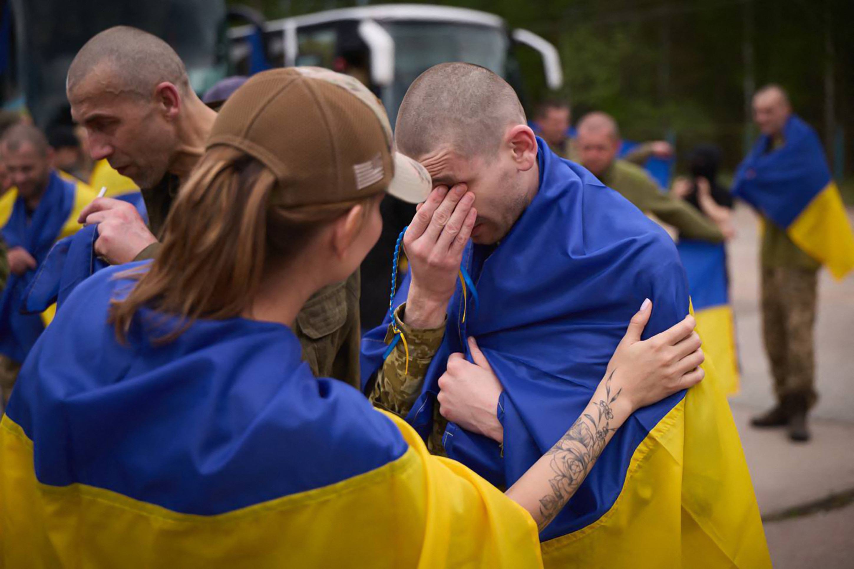 Soldados ucranianos se emocionam ao serem recebidos por familiares In this handout photograph taken and released by the Ukrainian Presidential Press Service on May 24, 2025, a Ukrainian prisoner of war (POW) wrapped with a national flag reacts following an exchange at an undisclosed location, amid the Russian invasion in Ukraine. Russia and Ukraine exchanged 307 POWs from each country on May 24, 2025, the Russian defence ministry said on the second day of the biggest prisoner swap in more than three years of conflict. (Photo by Handout / UKRAINIAN PRESIDENTIAL PRESS SERVICE / AFP) / RESTRICTED TO EDITORIAL USE - MANDATORY CREDIT "AFP PHOTO / UKRAINIAN PRESIDENTIAL PRESS SERVICE" - NO MARKETING NO ADVERTISING CAMPAIGNS - DISTRIBUTED AS A SERVICE TO CLIENTS