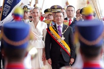 O presidente reeleito do Equador, Daniel Noboa (C), e sua esposa, a primeira-dama Lavinia Valbonesi (E), recebem honrarias ao entrar no Palácio Carondelet após sua posse na Assembleia Nacional em Quito, em 24 de maio de 2025       -  (crédito:  ARMANDO PRADO / AFP)