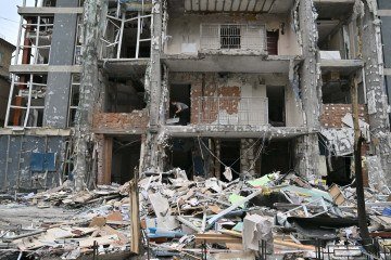 Morador limpa os escombros do apartamento destruído após um ataque de drone em Kiev, em 25 de maio de 2025       -  (crédito: Sergei SUPINSKY/AFP)