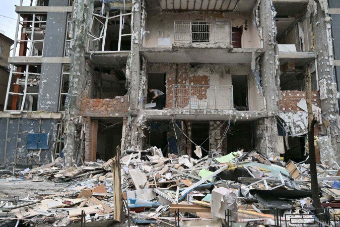 Morador limpa os escombros do apartamento destruído após um ataque de drone em Kiev, em 25 de maio de 2025 - (crédito: Sergei SUPINSKY/AFP) Morador limpa os escombros do apartamento destruído após um ataque de drone em Kiev, em 25 de maio de 2025 - (crédito: Sergei SUPINSKY/AFP)