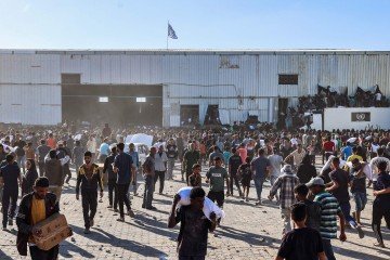 Palestinos desabrigados invadem armazém da ONU, em Der el Balah (centro), e carregam sacos de alimentos  -  (crédito: Eyad Baba/AFP)