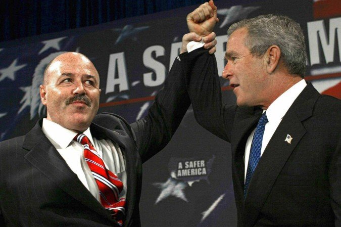  (FILES) Bernard Kerik, former police comissioner of New York City (L), holds the hand of US President George W. Bush in a victory pose as Bush is introduced 18 October 2004 to a crowd of supporters at the Evesham Recreation Center in Marlton, New Jersey. Former NYPD Commissioner Bernard Kerik died on May 29, 2025 at the age of 69. In a post on social media, FBI Director Kash Patel said Kerik passed away on Thursday after a private battle with an illness. Kerik was former New York City Mayor Rudy Giulianis commissioner from 2000 to 2001, and served during the 9/11 terrorist attacks. (Photo by Paul J. RICHARDS / AFP)       