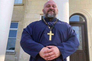 Theodore — que até recentemente rejeitava toda religião, e agora se converteu — levanta pesos três vezes por semana com o padre Moses -  (crédito: BBC)