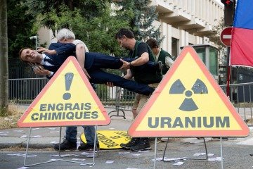 Ativistas ambientais do Greenpeace com a estátua de cera representando o presidente francês Emmanuel Macron -  (crédito: Emma DA SILVA/AFP)