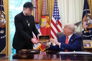 O presidente dos EUA, Donald Trump, aperta a mão de Elon Musk após o republicano presenteá-lo com uma 'chave da Casa Branca'       
 -  (crédito: Kevin Dietsch/Getty Images/AFP)