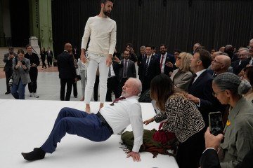 O presidente brasileiro Luiz Inácio Lula da Silva tenta reproduzir um movimento de acrobatas durante visita a uma exposição como parte de sua visita de Estado à França, em 6 de junho de 2025 -  (crédito: Michel Euler/POOL/AFP)