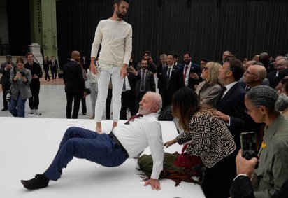 O presidente brasileiro Luiz Inácio Lula da Silva tenta reproduzir um movimento de acrobatas durante visita a uma exposição como parte de sua visita de Estado à França, em 6 de junho de 2025   -  (crédito: Michel Euler/POOL/AFP)
