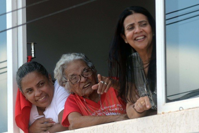 Muitas pesoas acompanham a festa das janelas ou varandas dos prédios e casas