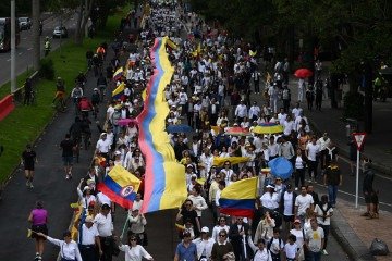 Manifestantes carregam faixa com as cores da bandeira do país durante marcha pela paz, em Bogotá  -  (crédito: Fotos: Raul Arboleda/AFP)