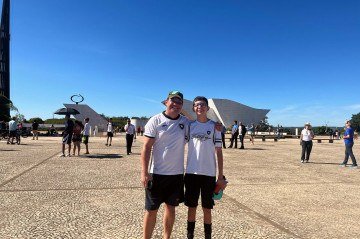 João e Ricardo asssistem à troca das bandeiras como uma tradição de pai e filho