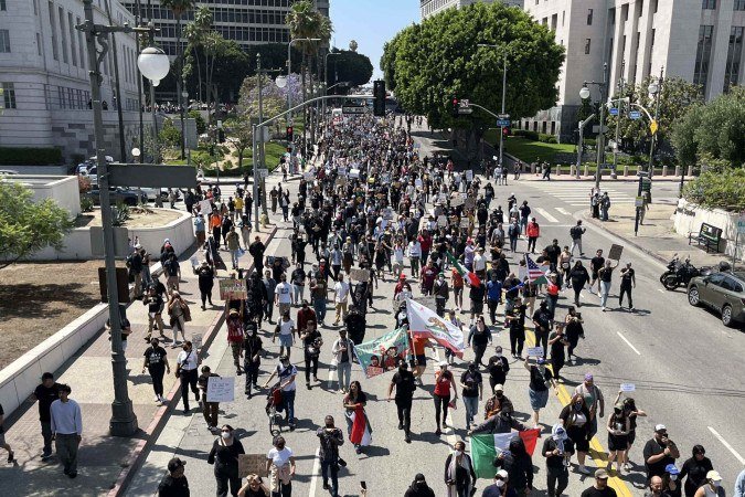  Demonstrators march during a protest following federal immigration operations, in Downtown Los Angeles, on June 8, 2025. US President Donald Trump deployed 2,000 troops on June 7 to handle escalating protests against immigration enforcement raids in the Los Angeles area, a move the state's governor termed "purposefully inflammatory." Federal agents clashed with angry crowds in a Los Angeles suburb as protests stretched into a second night Saturday, shooting flash-bang grenades and shutting part of a freeway amid raids on undocumented migrants, reports said. (Photo by Bastien INZAURRALDE / AFP)       