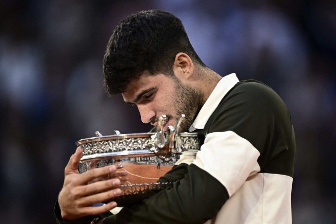 O abraço carinhoso de Alcaraz com o quinto troféu de Grand Slam da carreira - (crédito: Julien de Rosa/AFP) O abraço carinhoso de Alcaraz com o quinto troféu de Grand Slam da carreira - (crédito: Julien de Rosa/AFP)