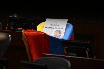 A cadeira ocupada pelo parlamentar no Senado é coberta pela bandeira colombiana, com uma foto dele e a frase: 