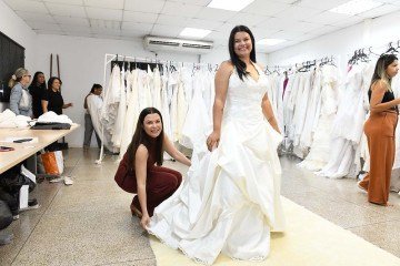 A secretária Marcela Passamani confere os detalhes do vestido que será usado pela noiva Sheila da Silva  -  (crédito:  Jhonatan Vieira/Sejus)