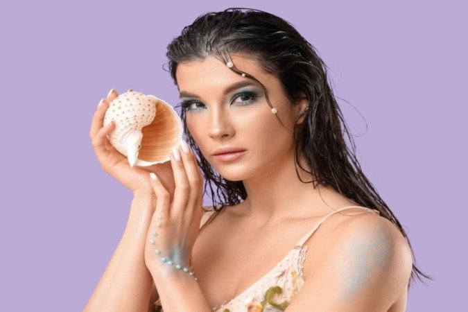 Tons azulados, pele iluminada e brilho molhado compõem o look conhecido como mermaidcore (Imagem: Pixel-Shot | Shutterstock) - (crédito: EdiCase) Tons azulados, pele iluminada e brilho molhado compõem o look conhecido como mermaidcore (Imagem: Pixel-Shot | Shutterstock) - (crédito: EdiCase)