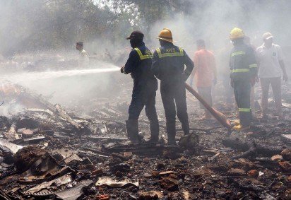 Equipes de resgate trabalham no local onde o avião caiu na Índia   -  (crédito: Sam PANTHAKY/AFP)