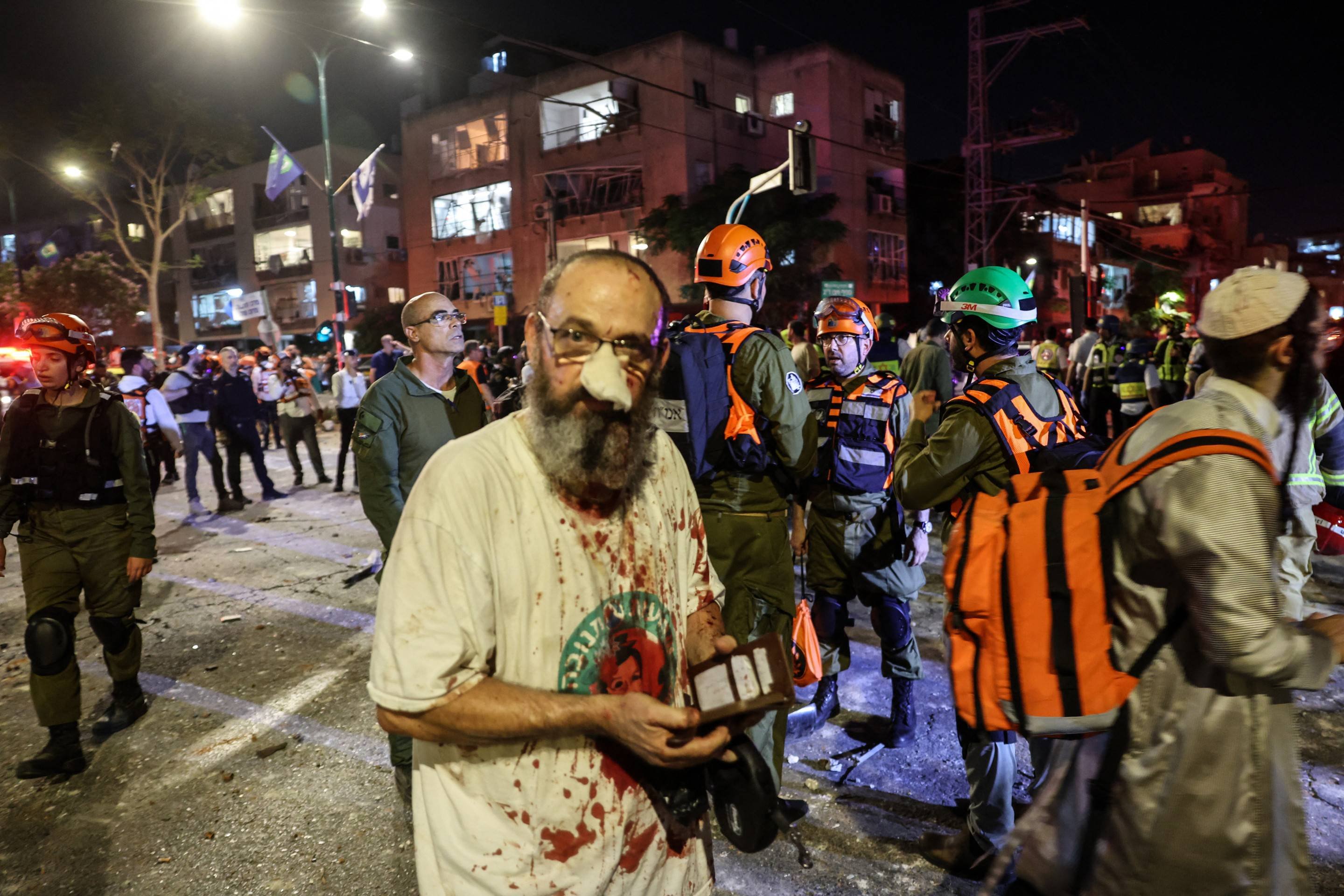 Ferido caminha entre socorristas, em Ramat Gan, ao lado de Tel Aviv Civil ferido caminha entre socorristas, em Ramat Gan, ao lado de Tel Aviv