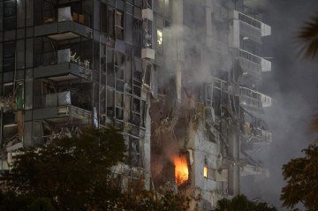 Fogo e fumaça sobem de edifício impactado por míssil, no centro de Tel Aviv  -  (crédito: Jack Guez/AFP)