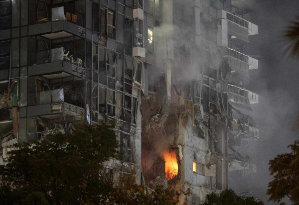 Fogo e fumaça sobem de edifício impactado por míssil, no centro de Tel Aviv - (crédito: Jack Guez/AFP)