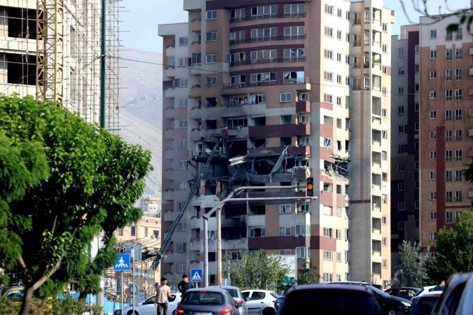 Fachada de prédio danificada em bombardeio israelense, em Teerã - (crédito: Atta Kenare/AFP) Fachada de prédio danificada em bombardeio israelense, em Teerã - (crédito: Atta Kenare/AFP)