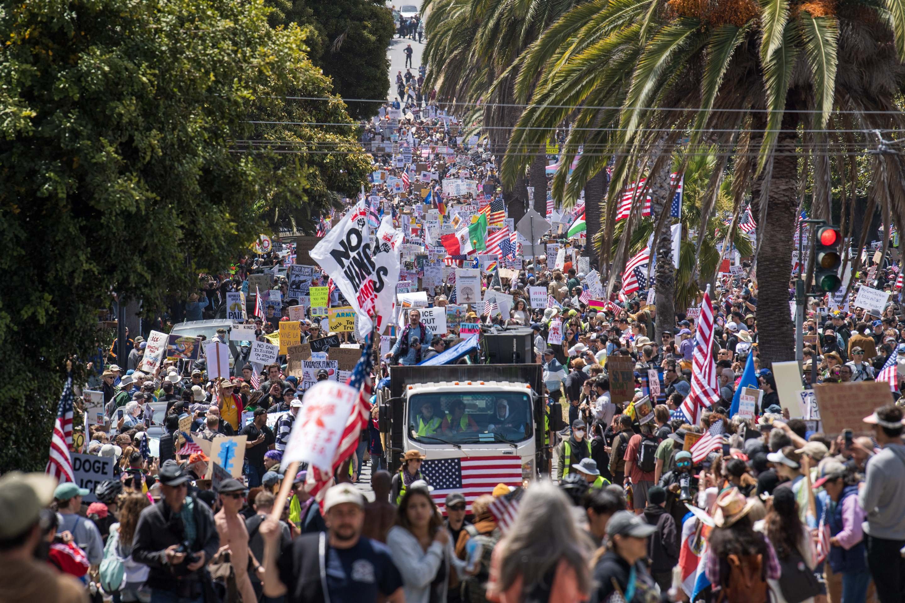  Demonstrators hold signs as they march down Dolores street protesting the Trump administration during the 