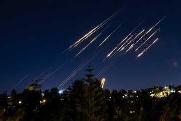 Missiles fired from Iran are pictured in the night sky over Jerusalem on June 14, 2025. Israel and Iran exchanged fire on June 14, a day after Israel unleashed an unprecedented aerial bombing campaign that Iran said hit its nuclear facilities, 'martyred' top commanders and killed dozens of civilians (Photo by Menahem Kahana / AFP)
- (crédito: AFP)