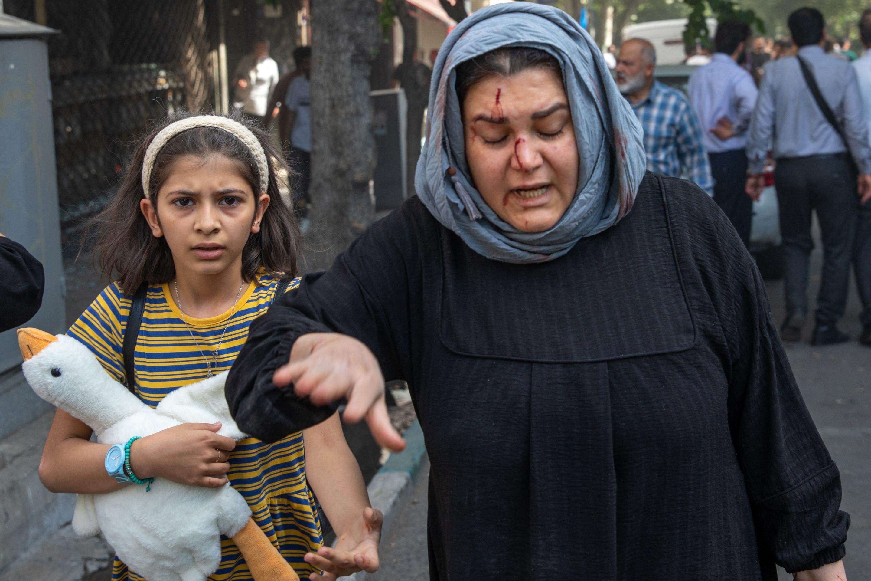 Uma mulher iraniana ferida reage após um suposto ataque israelense no Boulevard Keshavarz, no centro de Teerã, em 15 de junho de 2025 