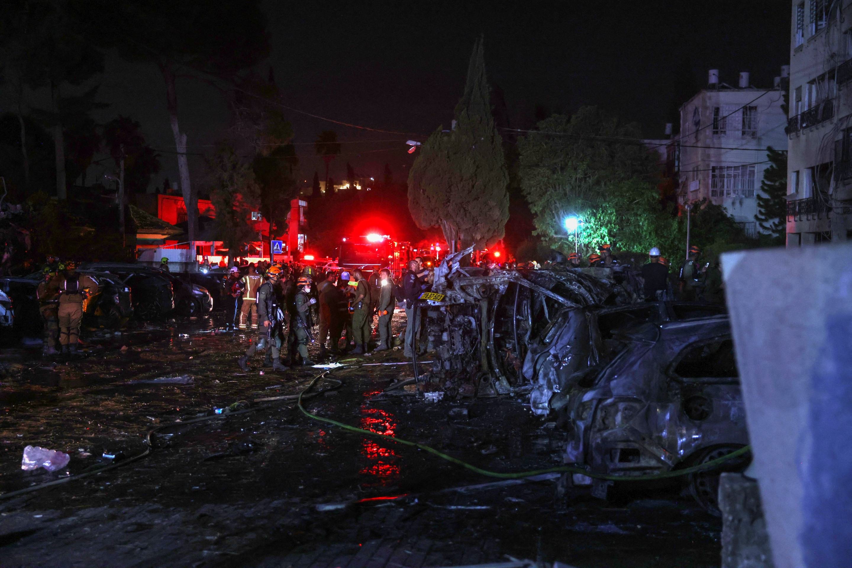 Membros dos serviços de emergência e segurança israelenses são enviados para um local atingido por um foguete iraniano na cidade de Haifa em 15 de junho de 2025      