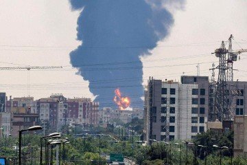 Uma coluna de fumaça preta sobe sobre uma refinaria de petróleo no sul de Teerã, após ter sido atingida por um ataque israelense durante a noite, em 15 de junho de 2025. -  (crédito: ATTA KENARE / AFP)