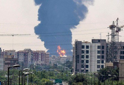 Uma coluna de fumaça preta sobe sobre uma refinaria de petróleo no sul de Teerã, após ter sido atingida por um ataque israelense durante a noite, em 15 de junho de 2025. -  (crédito: ATTA KENARE / AFP)