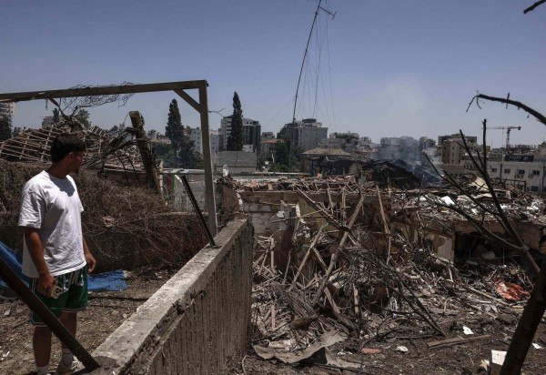 Um residente verifica a destruição após um ataque de míssil iraniano durante a noite em Rohovot, no centro de Israel. O Irã atacou Israel na madrugada de 15 de junho, com barragens de mísseis, depois que um ataque maciço teve como alvo as instalações nucleares, militares e de petróleo da república islâmica, e matou vários generais de alta patente - (crédito: Menahem Kahana / AFP)