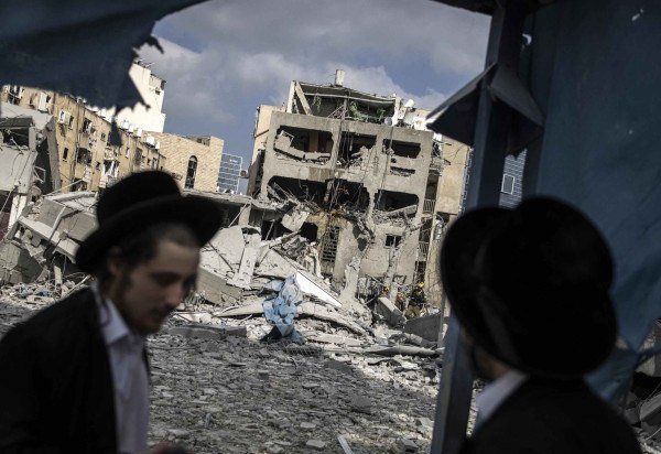 Judeus ultraortodoxos inspecionam danos à região de Bnei Brak, a leste de Tel Aviv, após bombardeio israelense - (crédito: John Wessels/AFP)