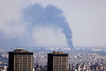  Smoke billows in the distance from an oil refinery following an Israeli strike on the Iranian capital Tehran on June 17, 2025. Israel and Iran exchanged fire again, the fifth day of strikes in their most intense confrontation in history, fuelling fears of a drawn-out conflict that could engulf the Middle East. (Photo by ATTA KENARE / AFP)
     -  (crédito:  AFP)