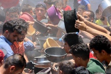 Distribuição de comida por parte de organização não governamental no bairro de Rimal, na Cidade de Gaza: fome generalizada e desespero -  (crédito: Omar Al-Qattaa/AFP)