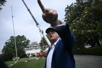 Trump falou com jornalistas enquanto trabalhadores instalam um grande mastro de bandeira no gramado sul da Casa Branca, em Washington, em 18 de junho de 2025       -  (crédito: Brendan SMIALOWSKI/AFP)