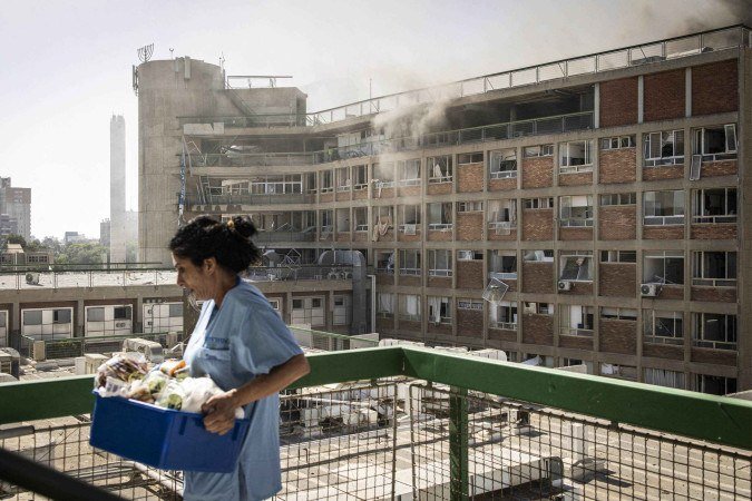 Uma enfermeira retira suplementos médicos do Soroka Hospital, após o prédio ser parcialmente destruído. Há informações de 40 feridos após o bombardeio - (crédito: AFP) Uma enfermeira retira suplementos médicos do Soroka Hospital, após o prédio ser parcialmente destruído. Há informações de 40 feridos após o bombardeio - (crédito: AFP)