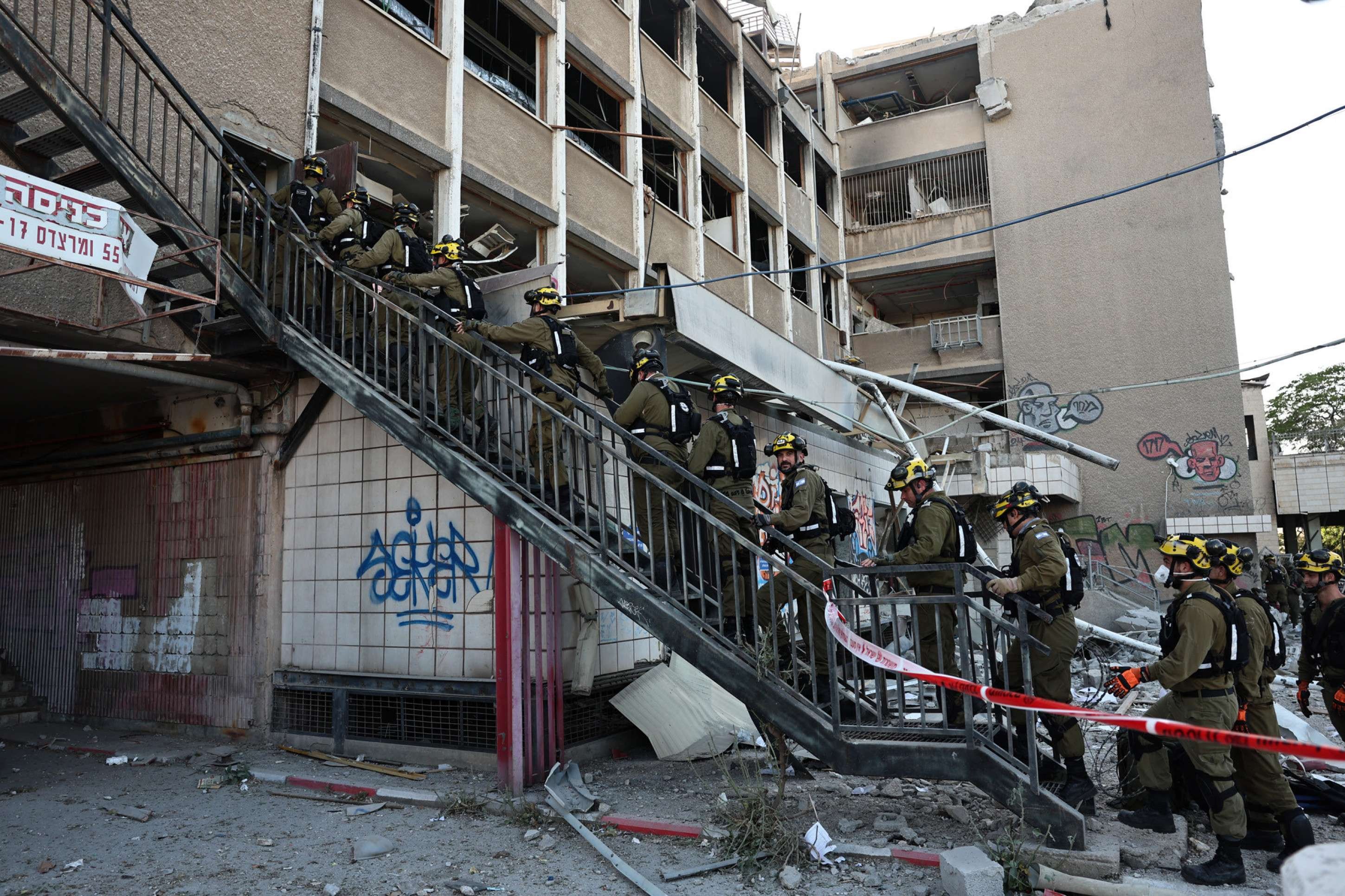Equipes de emergência israelenses entram em um prédio atingido por um ataque iraniano em Haifa em 20 de junho de 2025, em meio ao fogo cruzado entre Israel e o Irã. (Foto de Fadel SENNA / AFP)