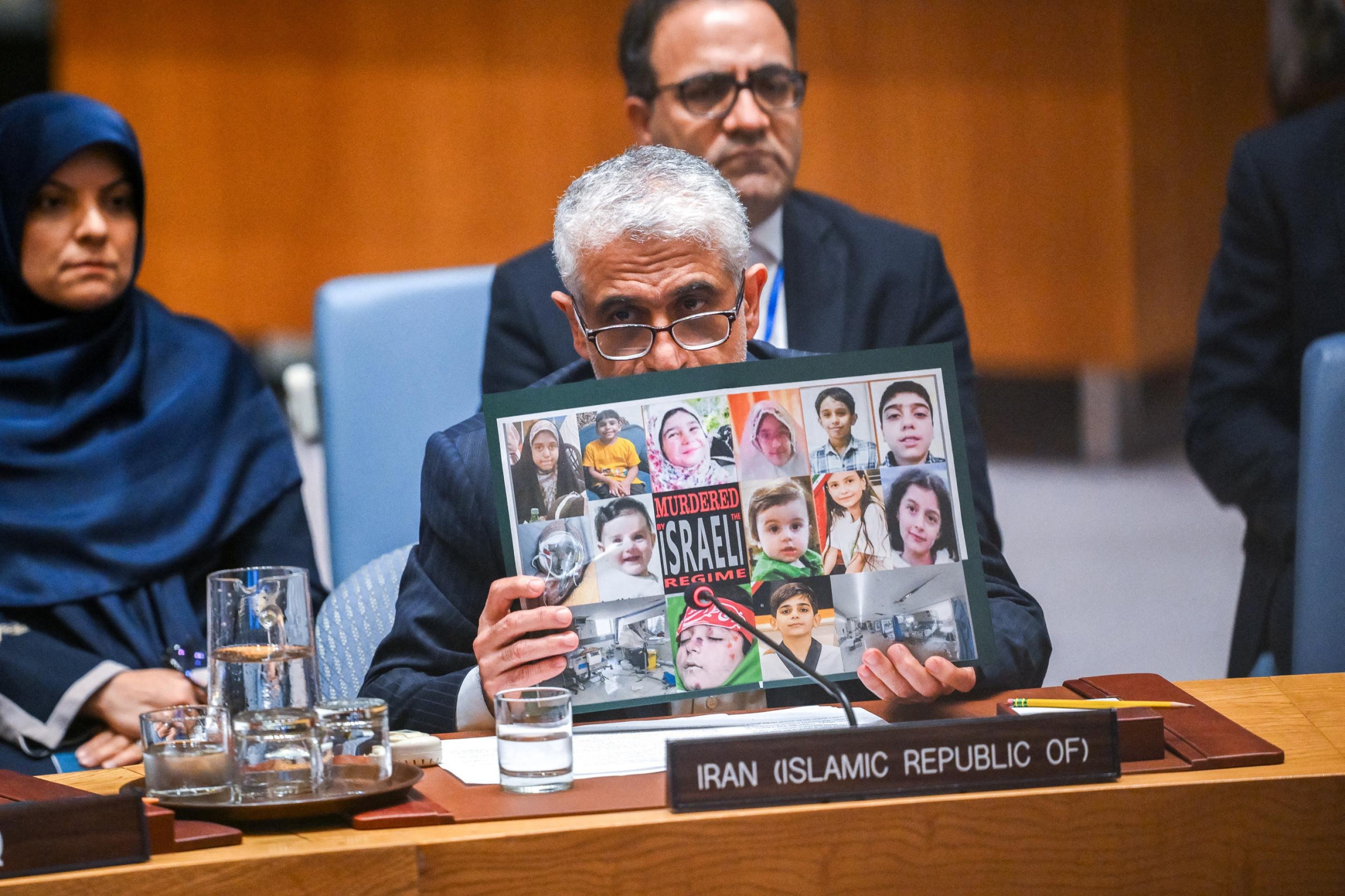 O representante do Irã na ONU, Amir Saeid Iravani, exibe fotos enquanto discursa durante uma reunião do Conselho de Segurança das Nações Unidas sobre o conflito entre Israel e o Irã, na sede da ONU em Nova York, em 20 de junho de 2025. O chefe da agência nuclear da ONU defendeu, em 20 de junho, uma solução diplomática para pôr fim aos ataques israelenses ao Irã, afirmando que sua agência poderia garantir um monitoramento rigoroso em qualquer acordo que coloque a tecnologia nuclear iraniana sob controle internacional. (Foto de ANGELA WEISS / AFP)