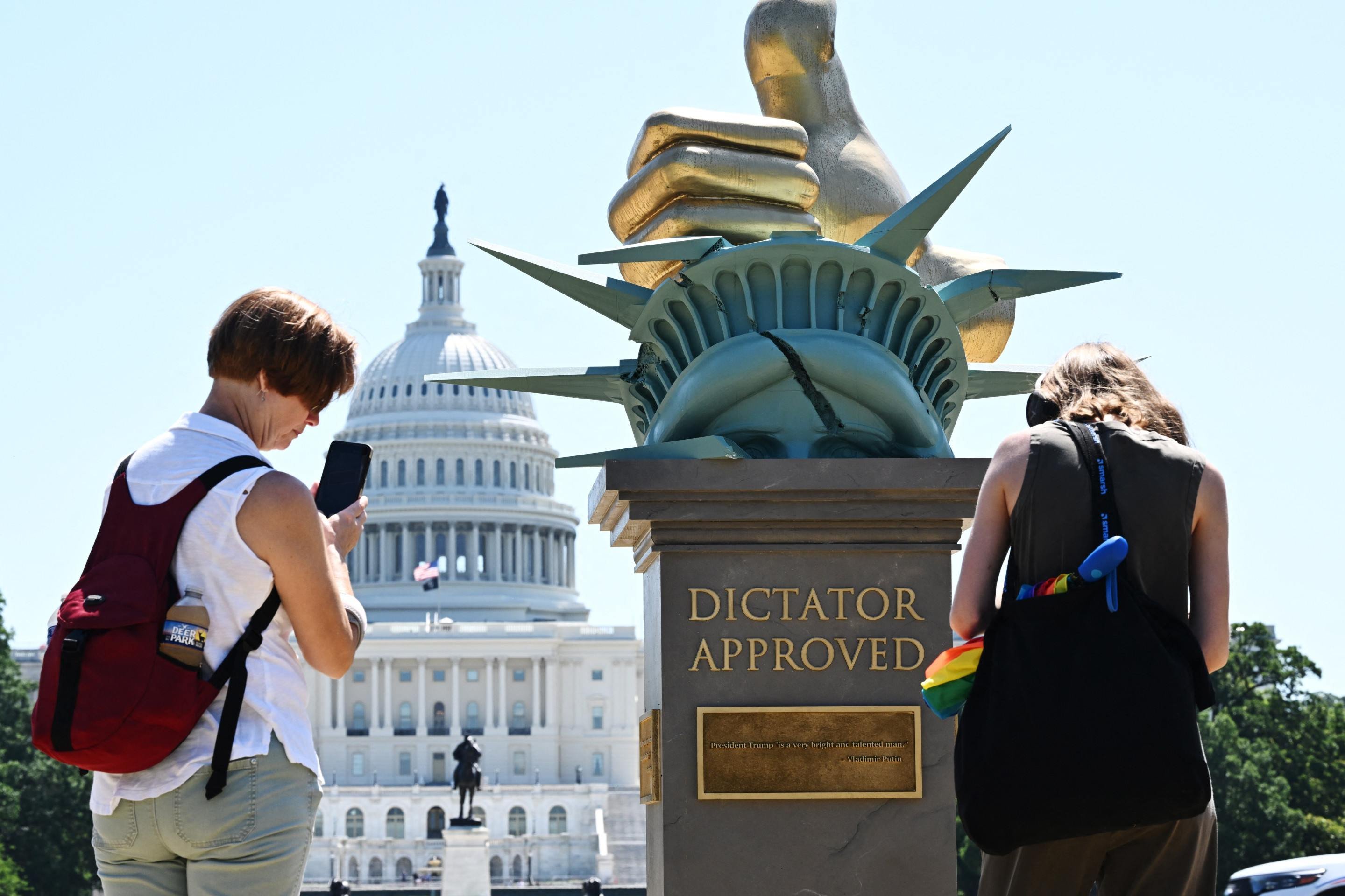 Pessoas olham para a estátua 