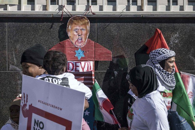  A cut out depicting the US President Donal Trump is tied to a wall as demonstrators gather in front of the US Consulate during a protest against the ongoing war between Israel and Iran and to express solidarity with the population of the Gaza Strip, in Johannesburg on June 21, 2025. (Photo by MARCO LONGARI / AFP)
      Caption 
