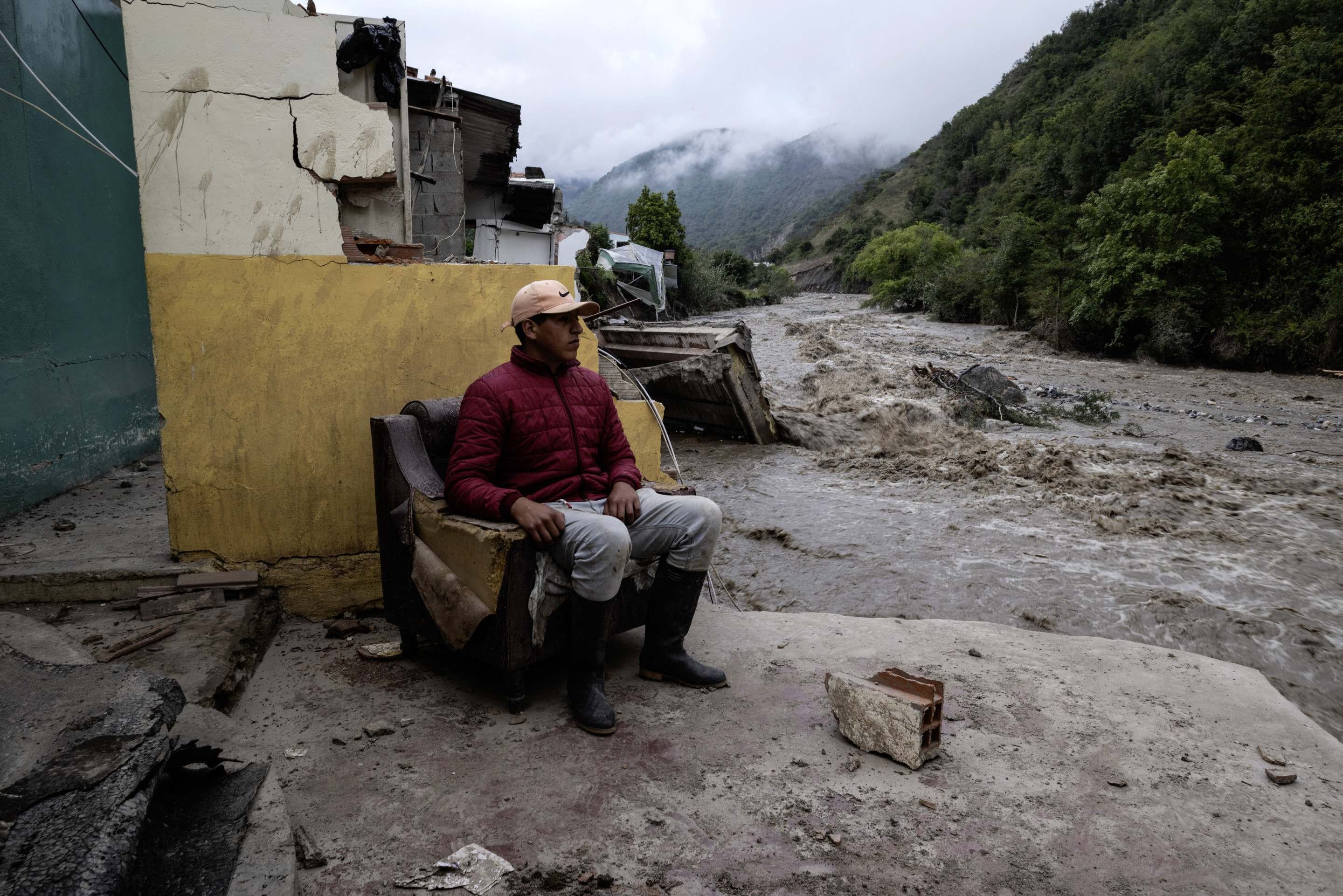 Um homem está sentado em uma casa destruída pela enchente do rio Chama em Escaguey, estado de Mérida, Venezuela, em 25 de junho de 2025      