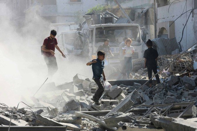 Palestinians walk through through rubble following Israeli strikes in Jabalia in the northern Gaza Strip on June 27, 2025. After more than 20 months of devastating conflict, rights groups say Gaza's population of more than two million face famine-like conditions. (Photo by Omar AL-QATTAA / AFP)
- (crédito: AFP) Palestinians walk through through rubble following Israeli strikes in Jabalia in the northern Gaza Strip on June 27, 2025. After more than 20 months of devastating conflict, rights groups say Gaza's population of more than two million face famine-like conditions. (Photo by Omar AL-QATTAA / AFP)
- (crédito: AFP)