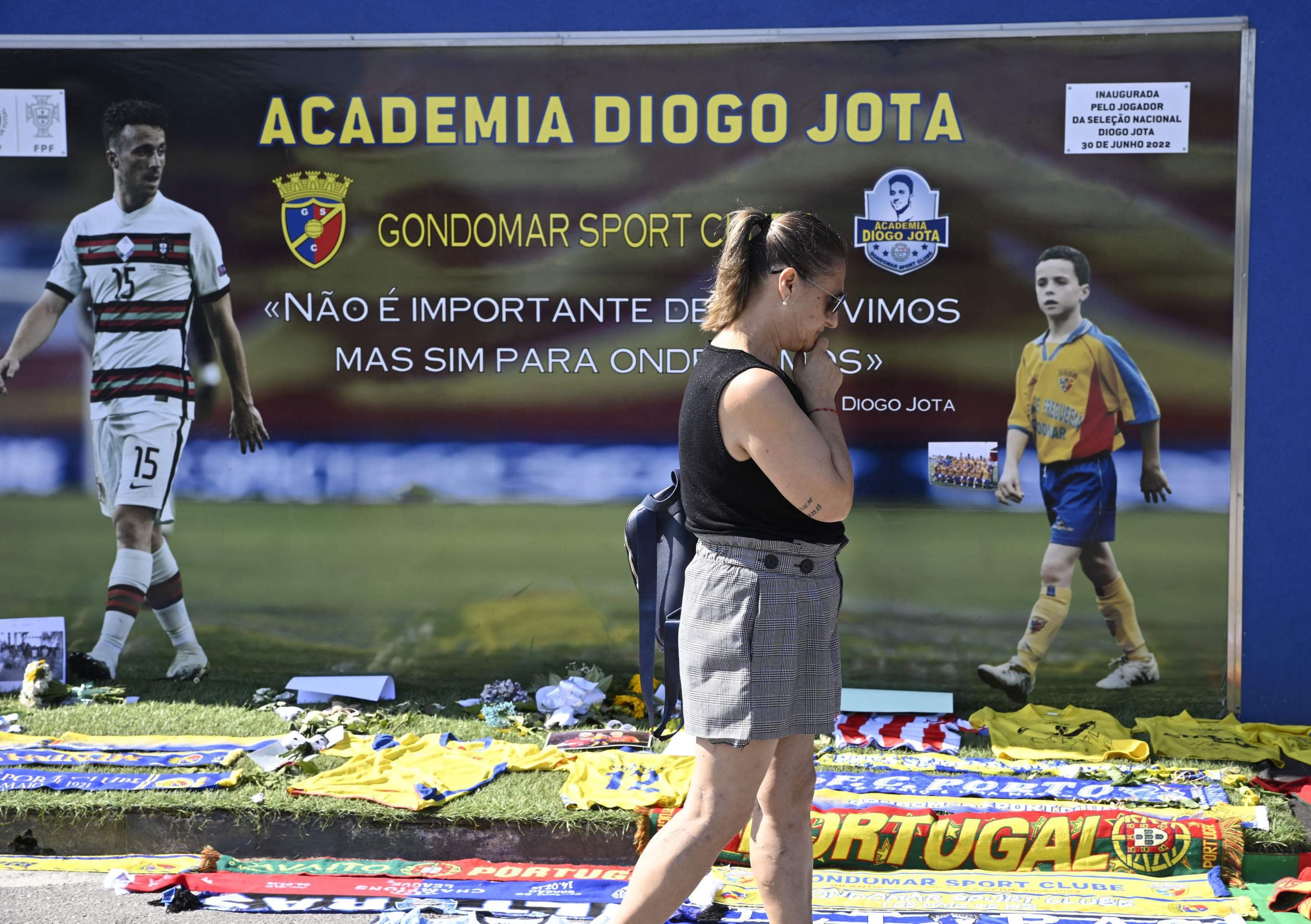 Uma mulher passa por um memorial dedicado ao atacante português do Liverpool, Diogo Jota, montado no estádio do Gondomar Sport Clube, onde o jogador iniciou sua carreira, em Gondomar, nos arredores do Porto, em 4 de julho de 2025. (Photo by MIGUEL RIOPA / AFP)       